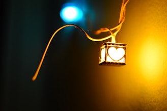 A close-up of a handcrafted tree-shaped pendant glowing softly with warm light