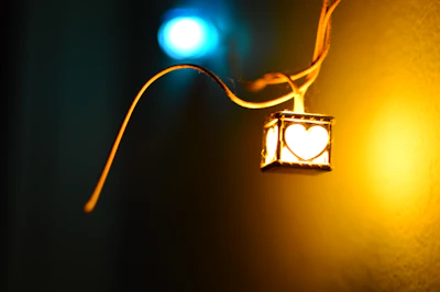 A warm shot of a pendant glowing softly against a backdrop of orange and pink hues.