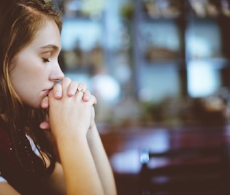 woman praying, in a with meditate posture