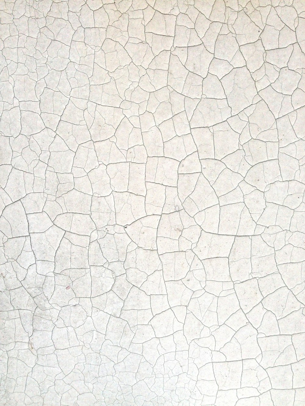 a close up of a white wall with cracks in it