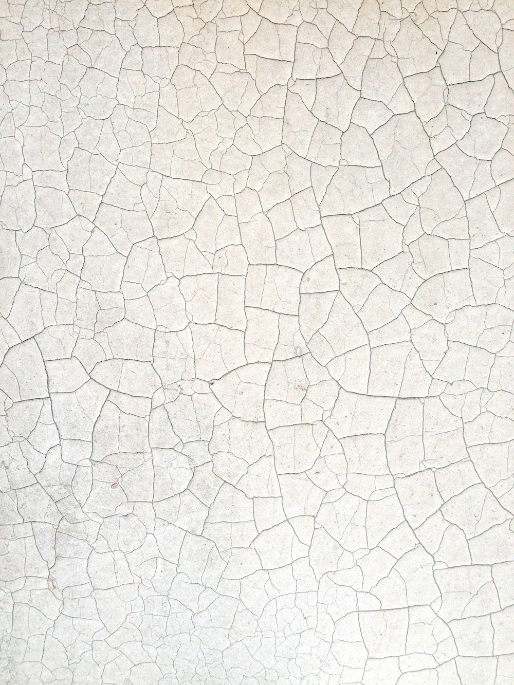Un primer plano de una pared blanca con grietas en ella