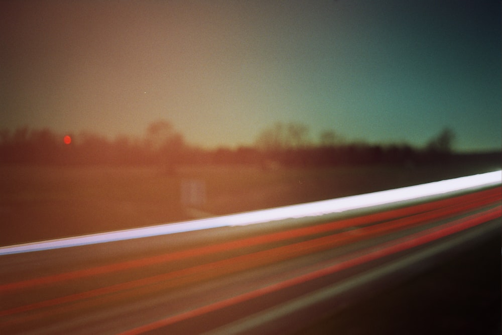 a blurry photo of a highway with trees in the background