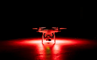 A dynamic drone soccer match in action inside a dark-themed arena with colorful LED lights.