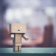 brown cardboard robot on green table