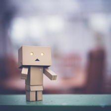 brown cardboard robot on green table