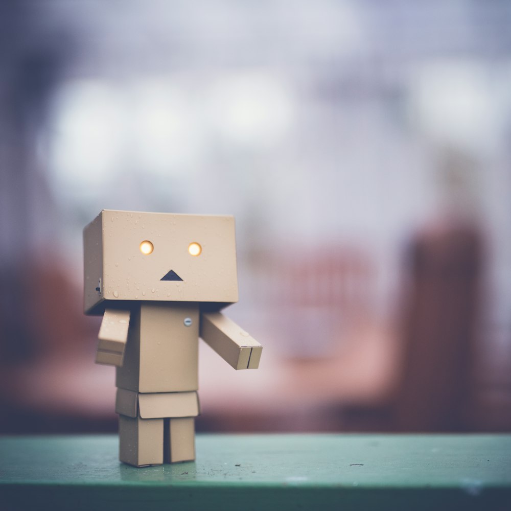 brown cardboard robot on green table