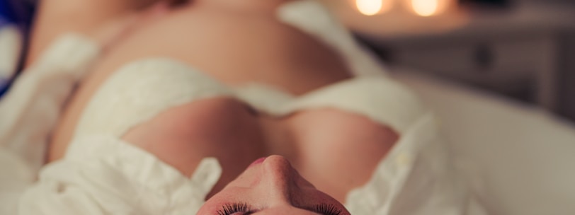 woman lying on bed wearing white lace panty