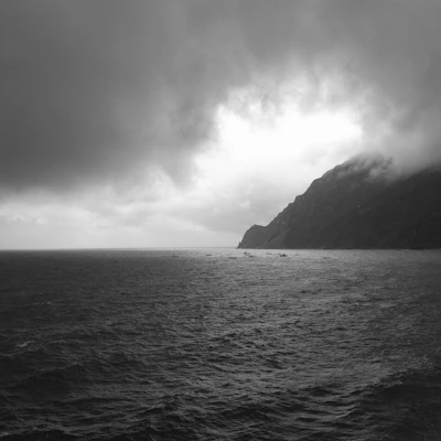 Close-up of ocean waves under a moody, overcast sky with cinematic tones.