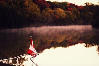 A serene morning view of a misty lake surrounded by autumn trees in Canada.