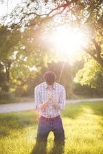 Text of prayers, photo of man kneeling on grass near tree