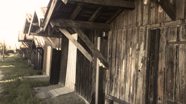 A row of different sized metal sheds with wood-like finishes lined up outdoors.