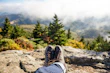 Close-up of hiking boots and camping gear arranged on a forest trail