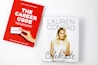 Two books are placed on a white surface. The book on the left is titled 'The Career Code' with a red cover, featuring a hand holding a business card, authored by Hillary Kerr and Katherine Power. The book on the right is titled 'Celebrate' with a white cover, displaying a photograph of a woman holding a cake.