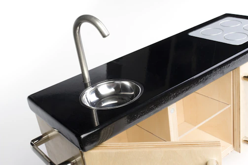 Miniature stove and sink set in a tailored miniature kitchen.