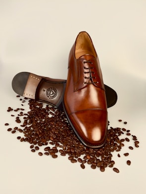 An elegant leather shoe resting on a polished wooden surface, showcasing fine stitching and texture.