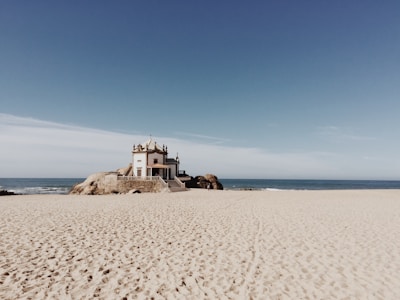 Pequena igreja branca construída sobre pedras na praia em Vila Nova de Gaia, Portugal