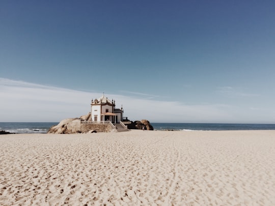 white concrete castle on beach in Chapel of Senhor da Pedra Portugal