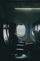woman sits on seat near window inside plane