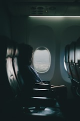 woman sits on seat near window inside plane