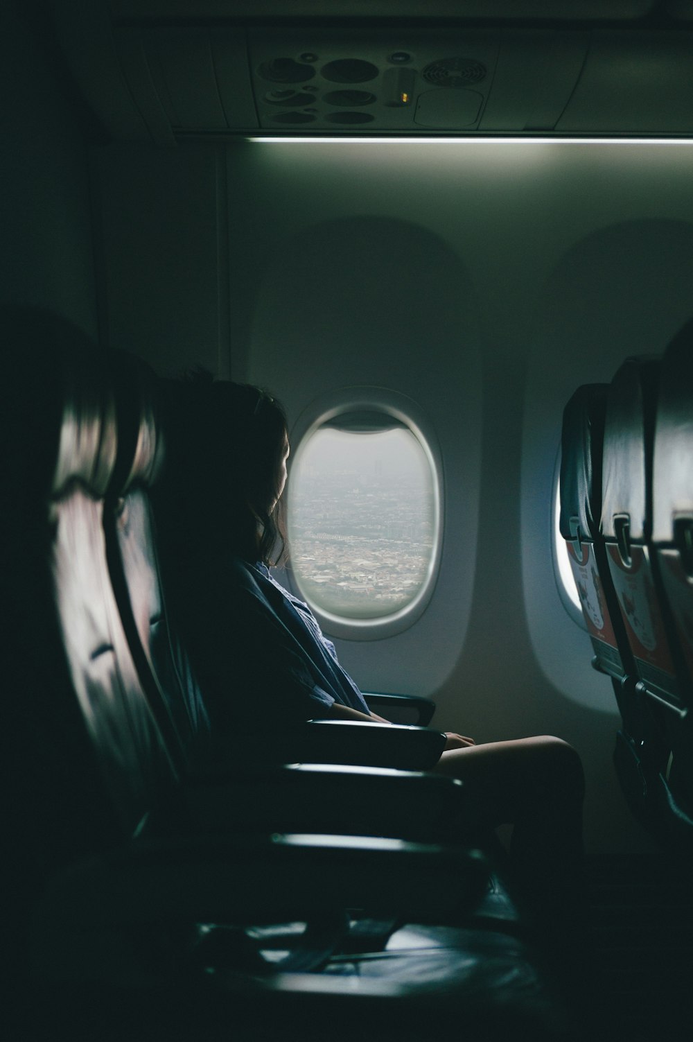 mujer se sienta en el asiento cerca de la ventana dentro del avión