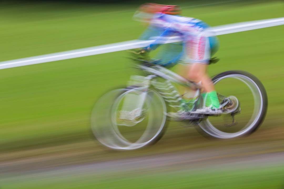 person biking on green field