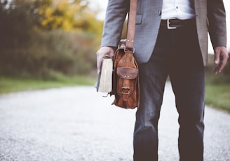 man holding book on road during daytime