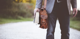 man holding book on road during daytime