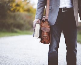 man holding book on road during daytime