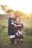 girl's left hand wrap around toddler while reading book during golden hour