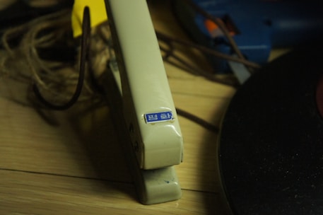 A close-up of sturdy folders and a classic stapler on a wooden office table.