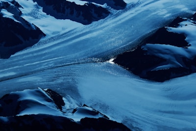 Aerial shot of a glacier surrounded by mountains.