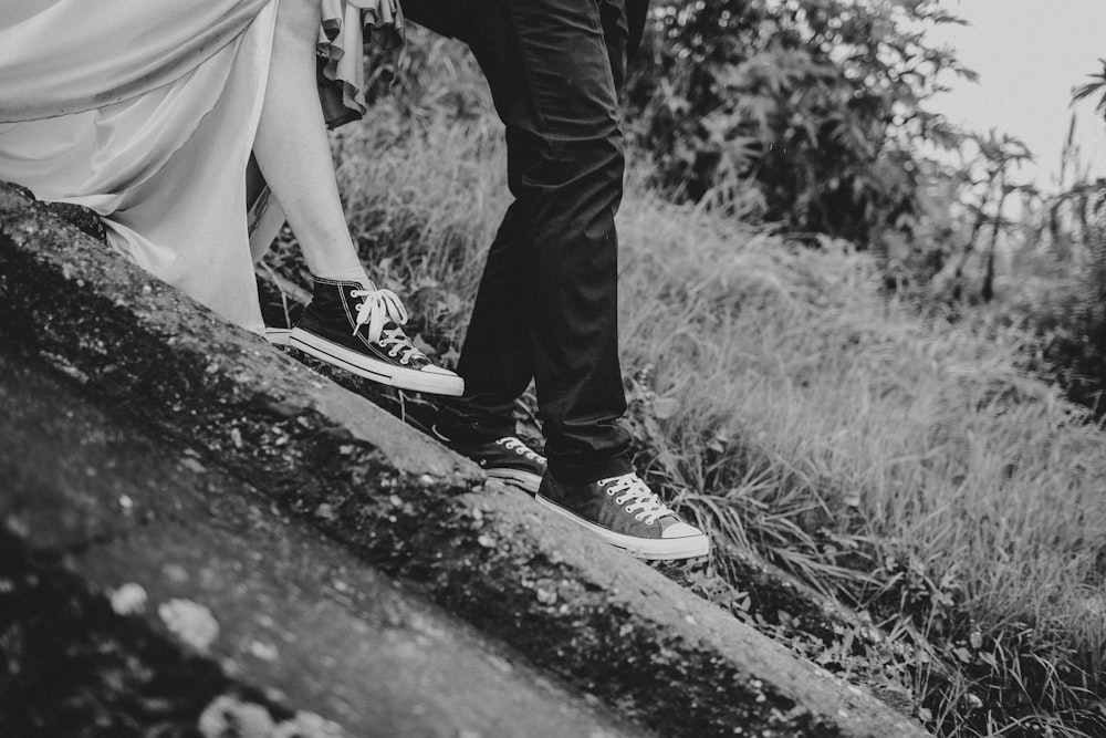 grayscale photography of man and woman standing on ground