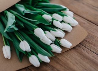 close-up photography of white petaled flower bouquet on brown wooden table