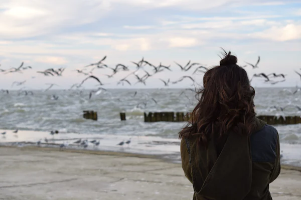 Woman looking at birds over water representing rural landscape near Pearsall Texas