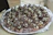 Man presenting a beautifully decorated tray of assorted gourmet brigadeiros with gold accents.