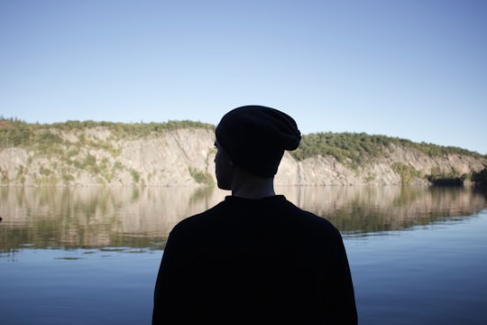 silhouette photography of person beside calm body of water in Bon Echo Provincial Park Canada