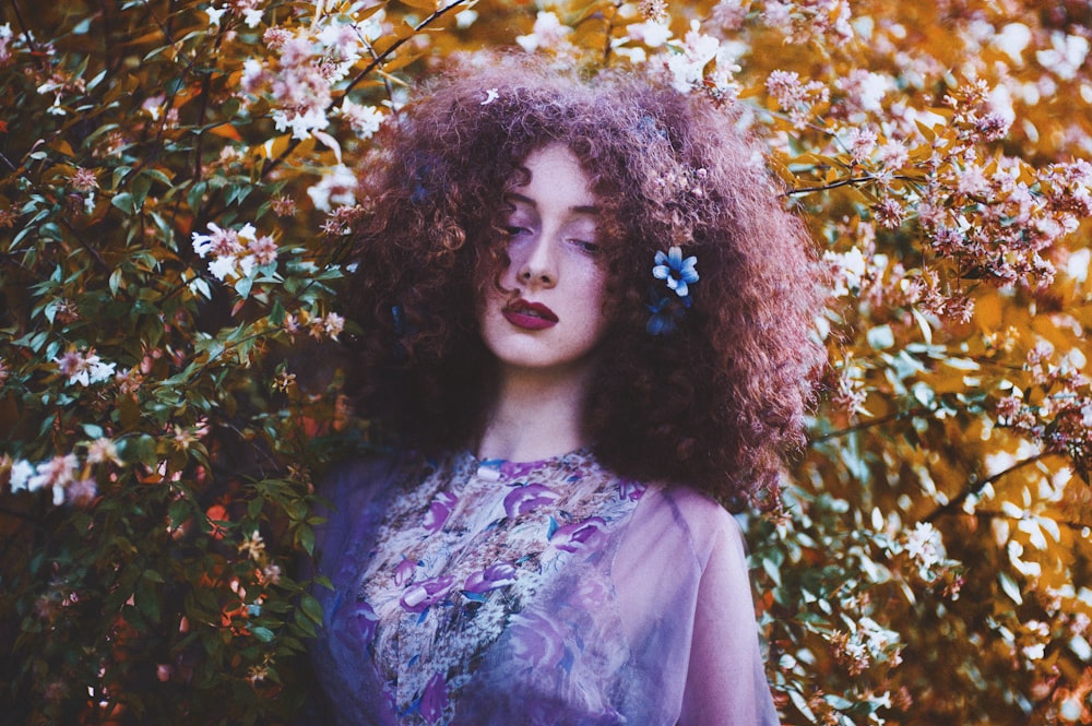 shallow focus photography of woman leaning on plant