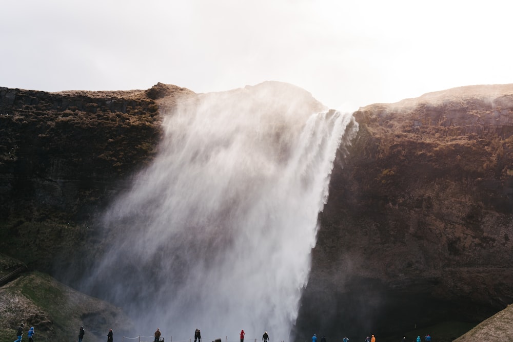 Cascate tra la scogliera marrone e nera durante il giorno