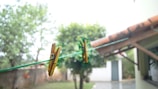 A lifestyle shot of a sunny backyard with colorful laundry and clothespins.