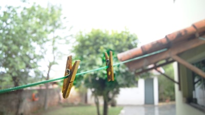 A lifestyle shot of a sunny backyard with colorful laundry and clothespins.
