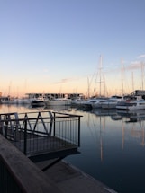 A serene yacht docked at sunset with calm waters reflecting the sky.