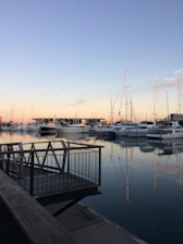 A serene marina scene with yachts docked, bathed in soft evening light.