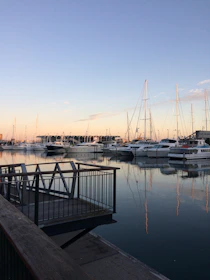 A serene marina scene with yachts docked, bathed in soft evening light.