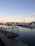 A serene marina scene with a clean, well-maintained boat docked at sunset.