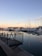 A serene marina scene with a yacht smoothly docking at sunset.