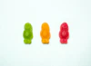 Red, Orange, Green Gummy bears next to each  other