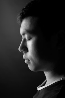 A serene black and white portrait capturing a quiet moment of reflection.