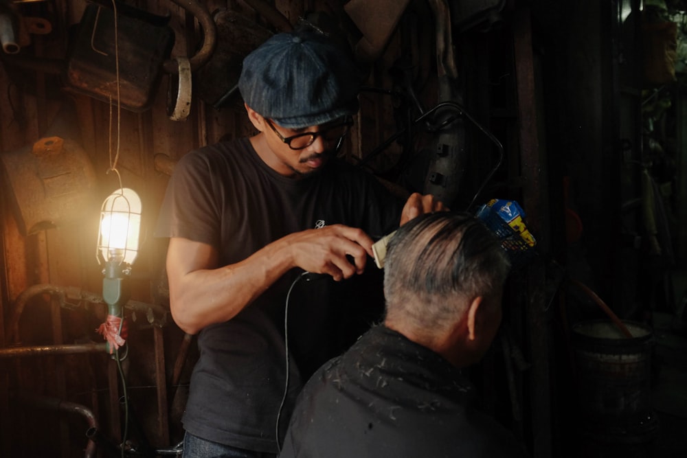 barber clipping the hair of the man