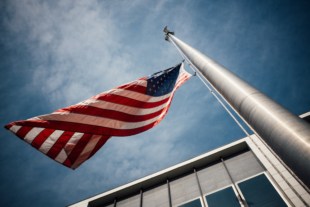 회색 기둥에 놓인 미국 국기의 로우 앵글 사진