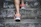 person wearing orange and gray Nike shoes walking on gray concrete stairs